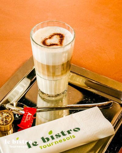 Latte macchiato d'exception avec une mousse onctueuse et sa garniture de cacao, pour une pause café décontractée.